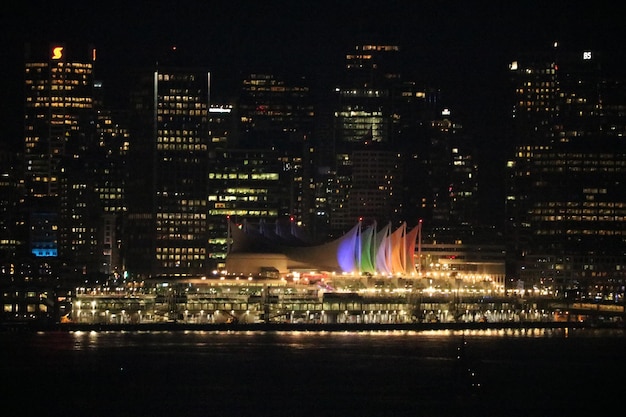 Photo illuminated buildings by river at night