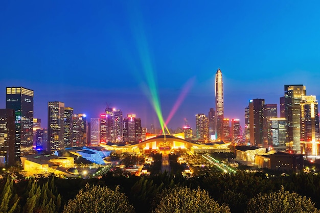 Illuminated buildings in city against blue sky