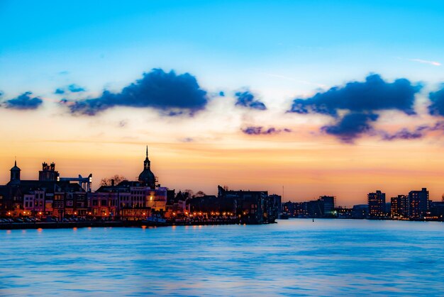 Illuminated buildings in city against sky during sunset