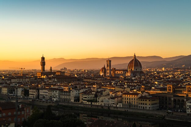 Photo illuminated buildings in city against sky during sunset