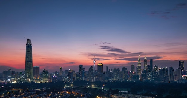 Photo illuminated buildings in city against sky during sunset