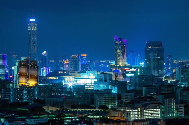 Photo illuminated buildings in city against sky at night