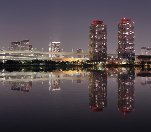 Photo illuminated buildings in city against sky at night