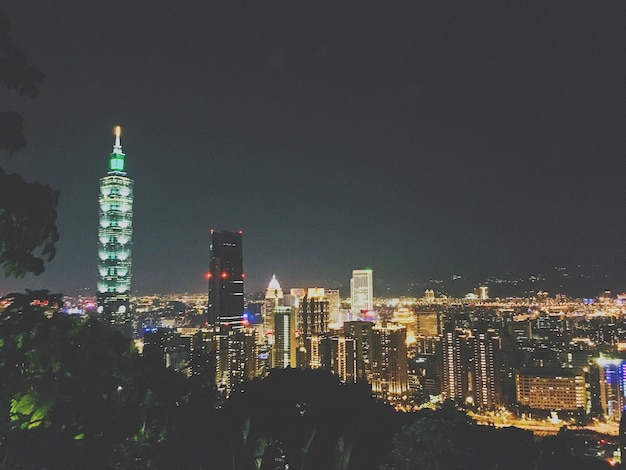 Illuminated buildings in city against sky at night