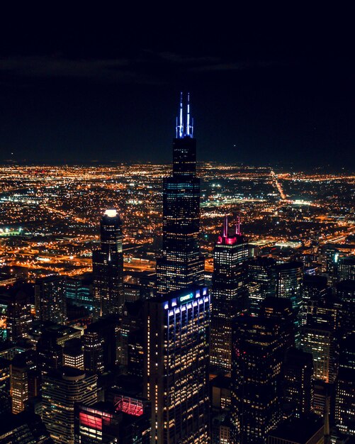 Photo illuminated buildings in city against sky at night