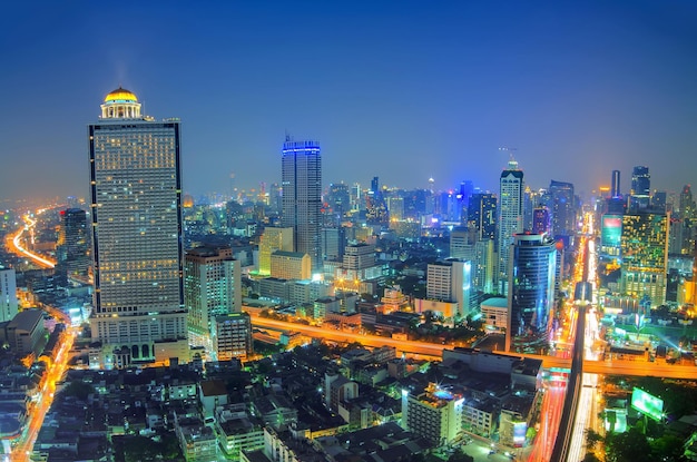 Illuminated buildings in city against sky at night