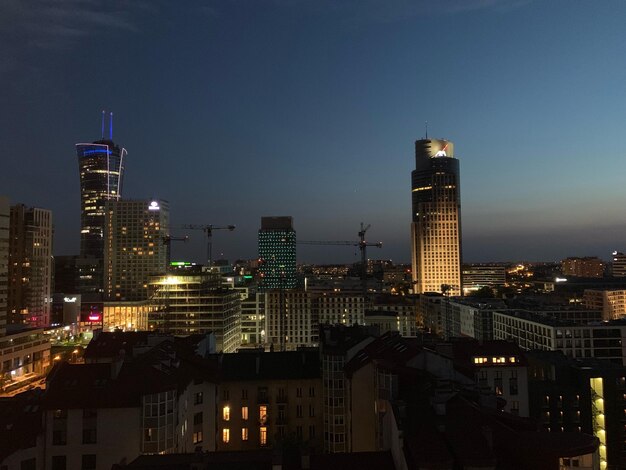 Illuminated buildings in city against sky at night