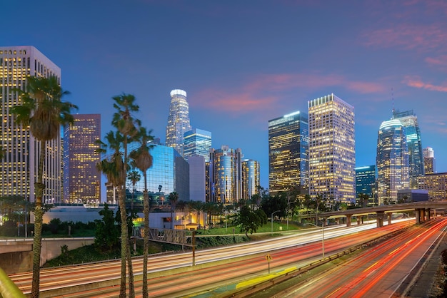 Illuminated buildings in city against sky at sunset