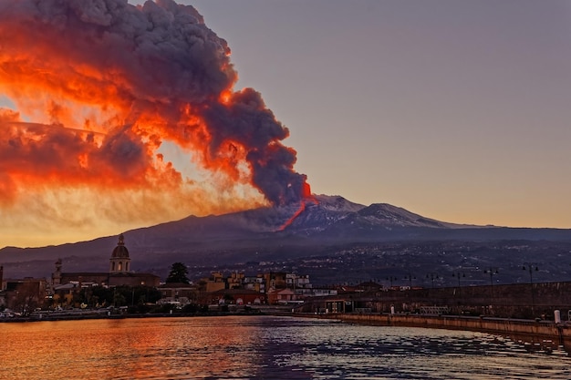 Foto edifici illuminati in città durante l'eruzione dell'etna