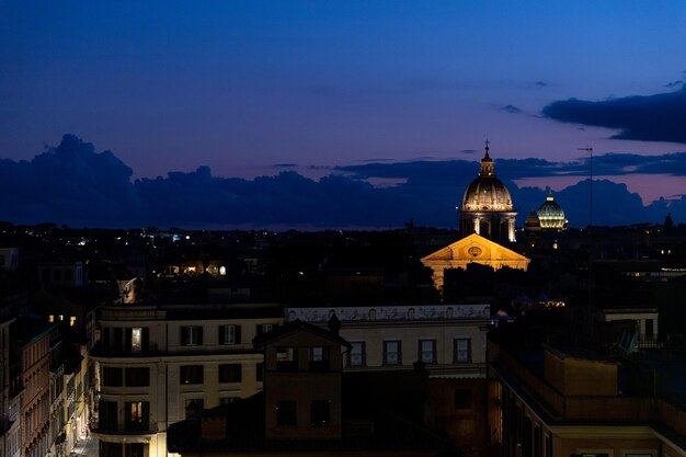 Illuminated buildings in city at sunset