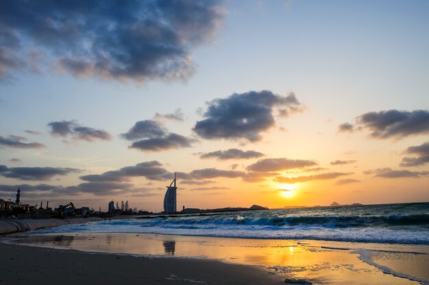 Il burj al arab e il jumeirah beach hotel illuminati al tramonto.