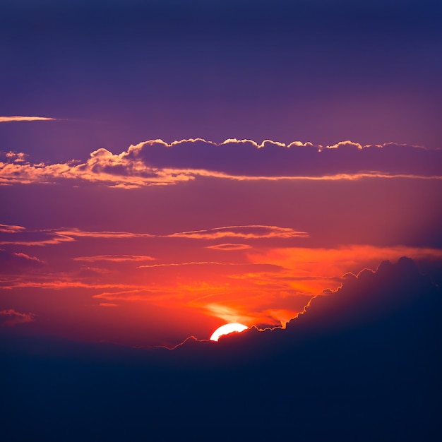 青い空を背景に日没時に太陽の雲に照らされて