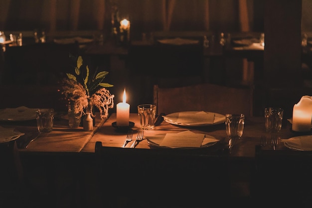 illuminated candles on dining table in darkroom