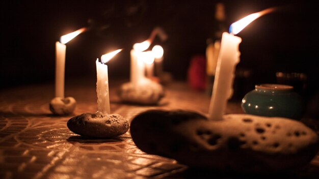 Photo illuminated candles on stones at night