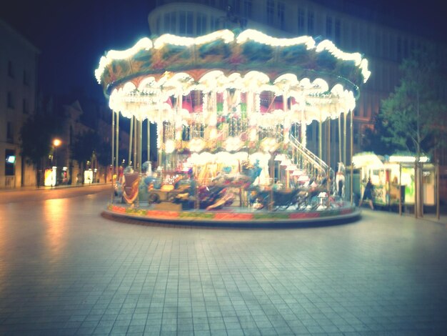 Illuminated carousel against sky at night