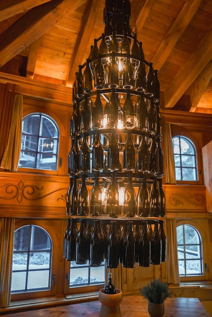 Illuminated chandelier made of bottles hanging in chalet