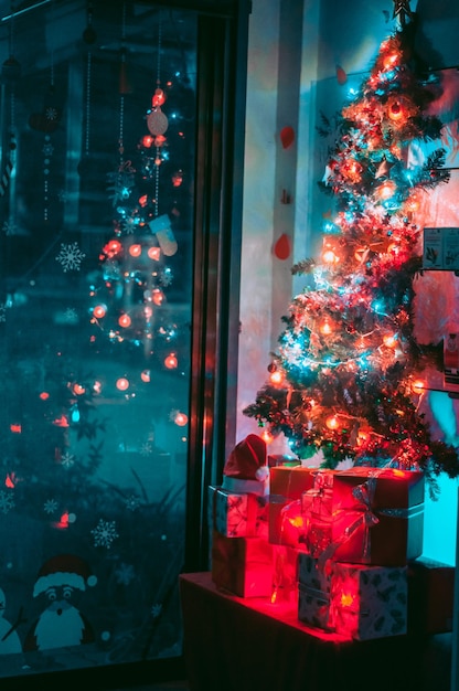 illuminated christmas tree by window at night