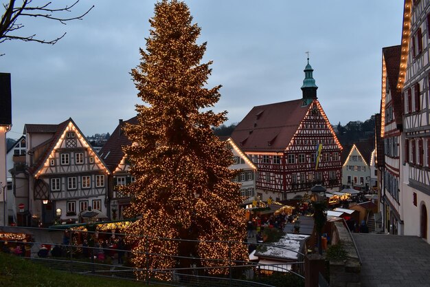 Foto albero di natale illuminato in città contro il cielo