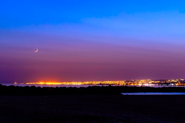 Illuminated city against sky at night