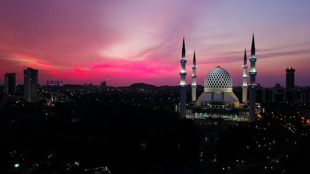 Illuminated city against sky during sunset