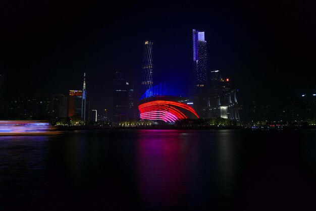 Photo illuminated city by river at night