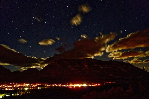 Foto città e montagne illuminate di notte