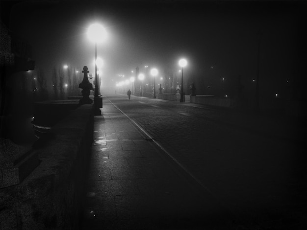 Photo illuminated city street against sky at night