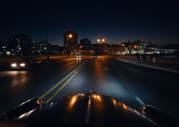 Illuminated city street against sky at night