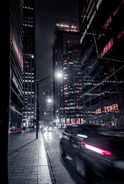 Photo illuminated city street and buildings at night