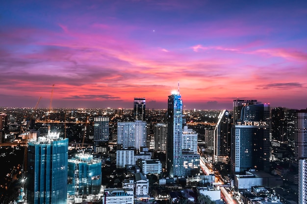 Illuminated cityscape against sky during sunset