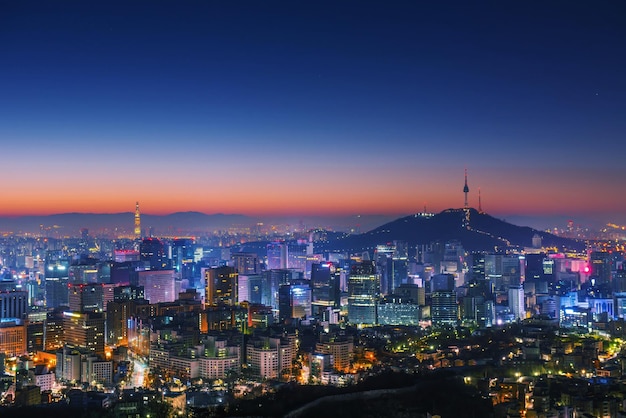 Photo illuminated cityscape against sky at dusk