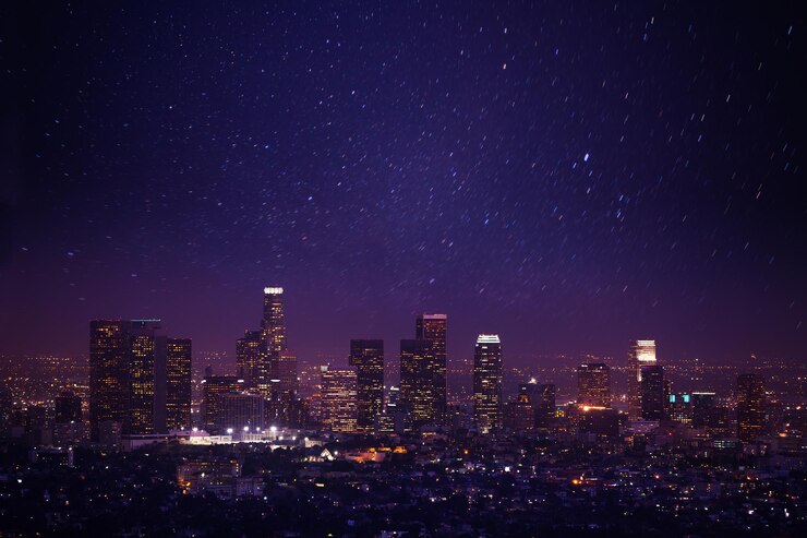 Photo illuminated cityscape against sky at night during snowfall