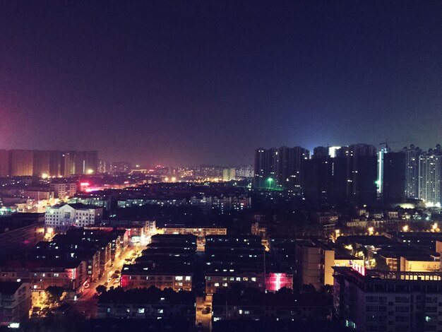 Illuminated cityscape against sky at night