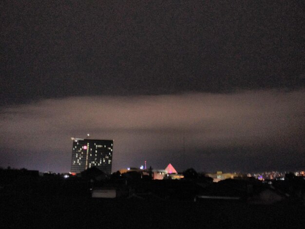 Illuminated cityscape against sky at night