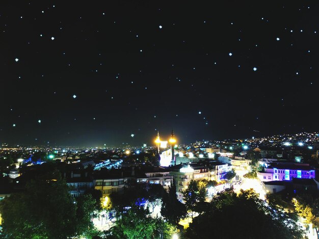 夜の星空の下の照らされた都市景色