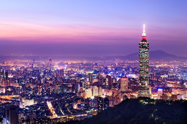 Illuminated cityscape and taipei 101 against sky at dusk