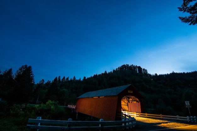 Photo illuminated covered footbridge against clear sky at dusk