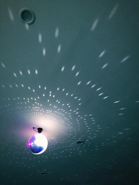 Фото Освещенный дискотечный шар на потолке