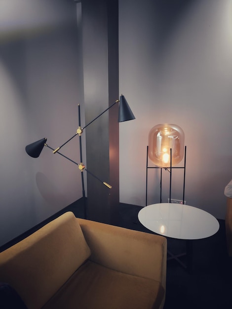 illuminated electric lamp on table against wall