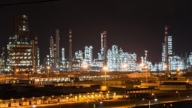 Illuminated factory against sky at night