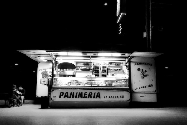 Illuminated food truck on street against clear sky at night