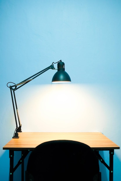 Foto lampada illuminata su tavolo contro la parete