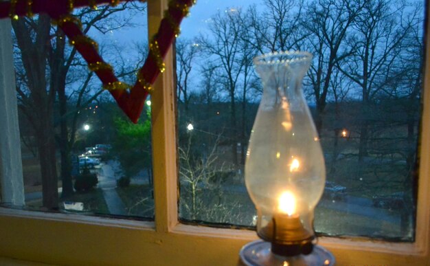 Illuminated light bulb against sky at night