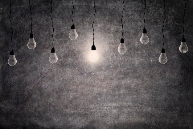 Photo illuminated light bulb hanging against wall