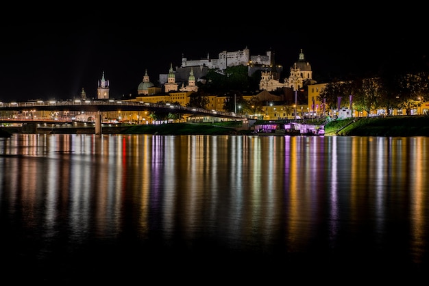 Foto luce illuminata che si riflette sul fiume contro il cielo di notte