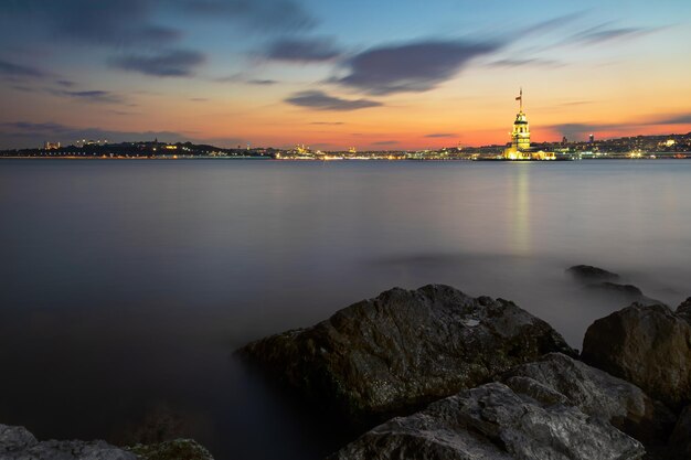 Photo illuminated maiden tower and istanbul panorama at sunset turkey