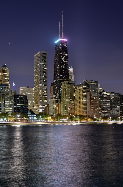 Photo illuminated modern buildings against clear sky by river