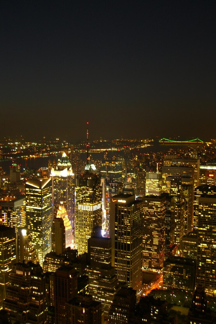 Photo illuminated modern buildings in city against clear sky at night