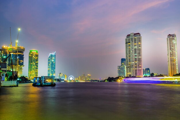 Photo illuminated modern buildings in city against sky at night