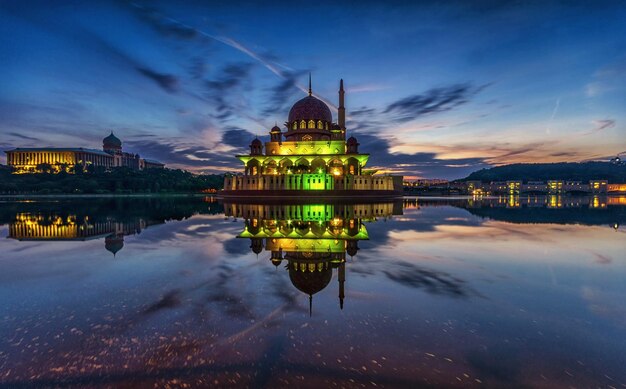 Foto moschea illuminata in città contro il cielo all'alba